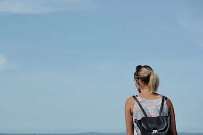 Rear view of woman looking at sea against clear sky