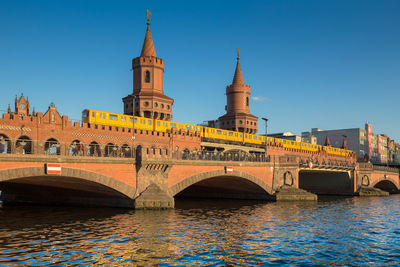 Arch bridge over river against buildings