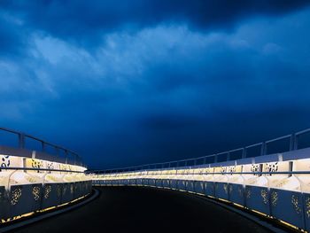 Bridge over road against sky at dusk