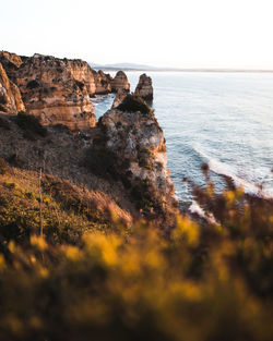 Rock formations in sea against clear sky