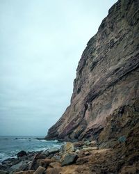 Rock formations by sea against sky