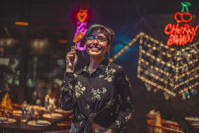 Portrait of smiling young woman standing at night