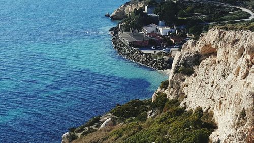 High angle view of buildings by sea and rock formation at cagliari