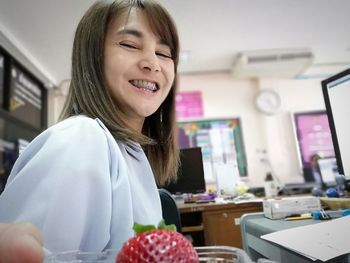 Smiling young woman sitting in office