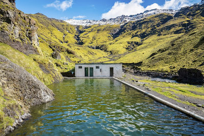 Scenic view of seljavallalaug natural geothermal hotspring pool against mountains