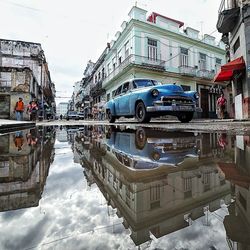 Reflection of buildings on street in city