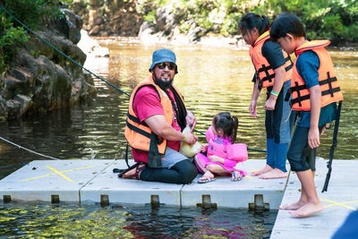 Family feeding fish at the kelah sanctuary in lubuk kejor.