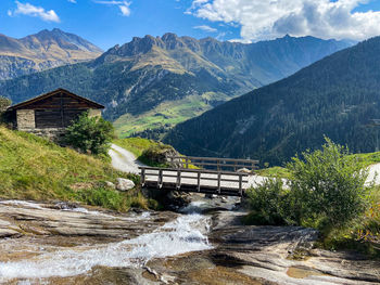 Scenic view of river by mountains against sky