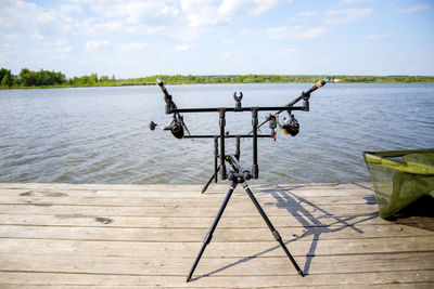 Fishing rods on pier over lake