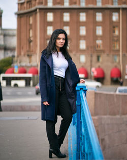 Full length of beautiful young woman standing in city
