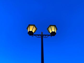 Low angle view of street light against blue sky