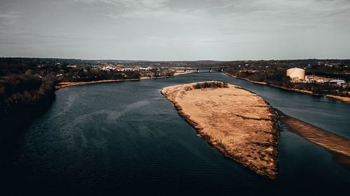 Aerial view of city by sea against sky