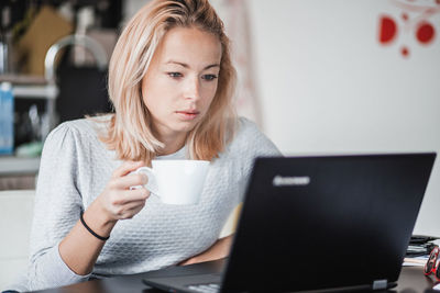 Young woman using laptop at home