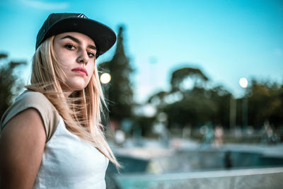 Portrait of young woman against sky