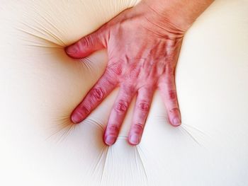 Close-up of hand touching mattress