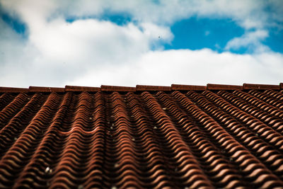 Roof tiles against cloudy sky