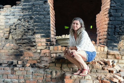 Portrait of a woman crouching in an old rustic wood-burning oven. maragogipinho, bahia, brazil.