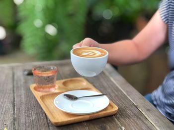 Midsection of woman holding coffee cup