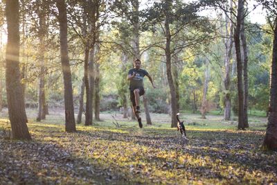 Man with arms raised in forest