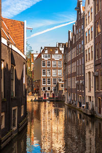 Canal amidst buildings against sky