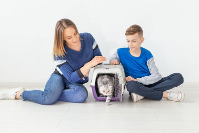 Portrait of a young woman with dog sitting on floor