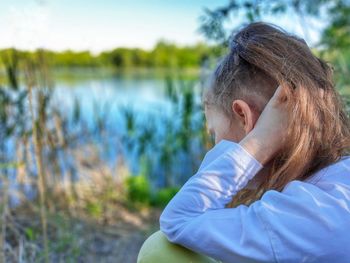 Portrait of woman sitting by lake