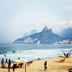 People at beach against sky