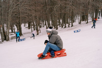 People skiing on snow covered field