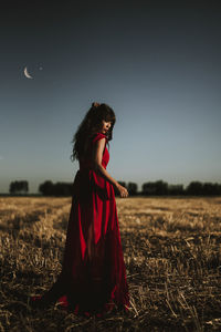 Woman standing on field against clear sky