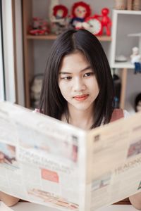 Portrait of young woman reading book