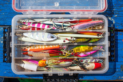 Directly above shot of colorful of fishing baits in box on table