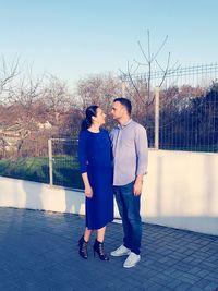 Full length of friends standing by water