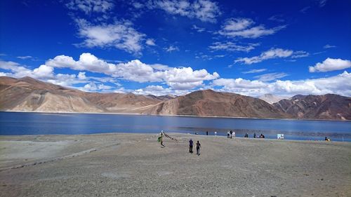 People on landscape against blue sky