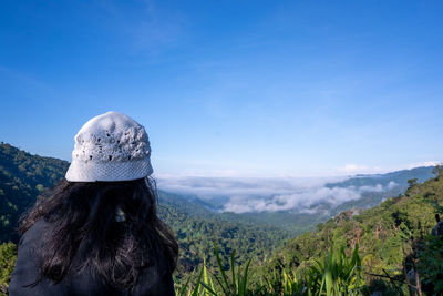 Rear view of woman looking at mountain against sky