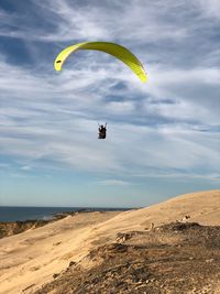 Person paragliding against sky