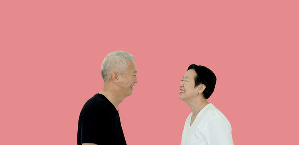 Man and woman standing against gray background