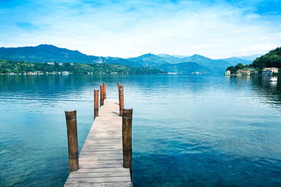 Wooden pier on orta san giulio lake with mountain scenery background. italy.