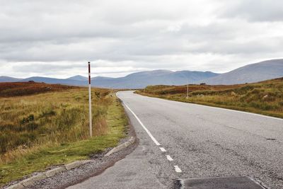 Empty road along countryside landscape