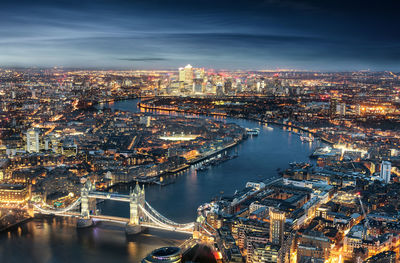 High angle view of tower bridge over thames river in illuminated city at night