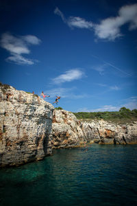 Three men jumping from cliff 