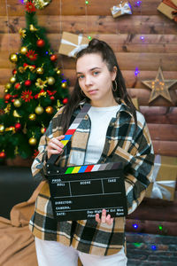 Portrait of young woman using mobile phone while sitting on table