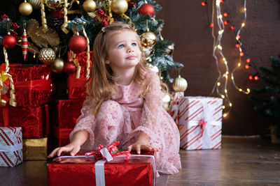 Cute girl looking away while holding gift box