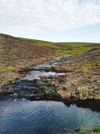 Scenic view of landscape against cloudy sky
