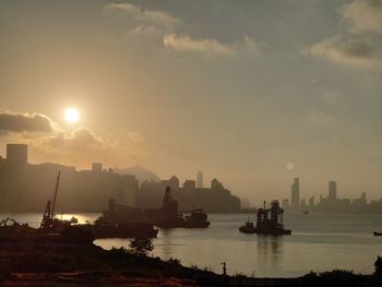 Scenic view of sea and buildings against sky during sunset