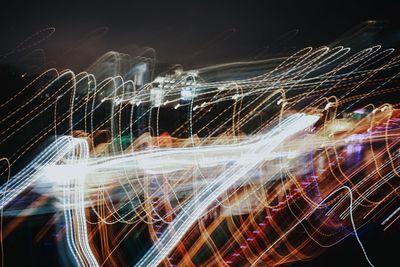 Light trails on bridge in city at night