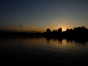 Scenic view of lake against sky at sunset