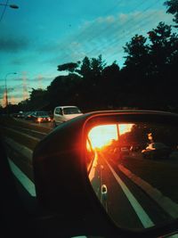 Traffic on road at sunset