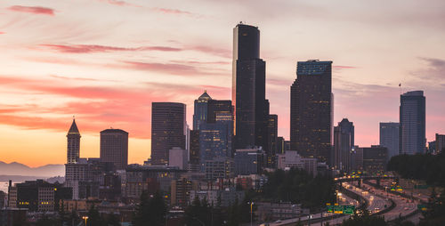 Skyscrapers in city at sunset