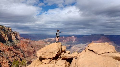 Tourists on rock formations against sky