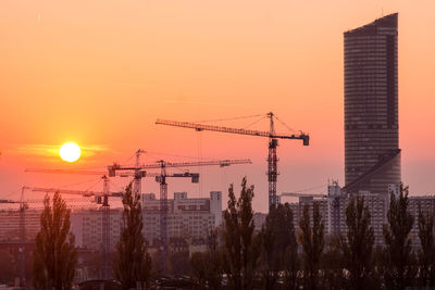 Modern buildings against sky during sunset